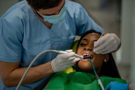 Photo of a dentist providing oral care treatment and medical service to a african american female...