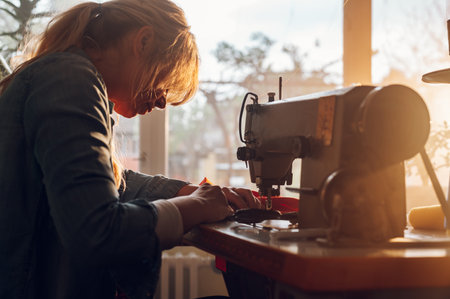 Portrait of a middle aged fashion designers working place at home while working on a sewing machine....