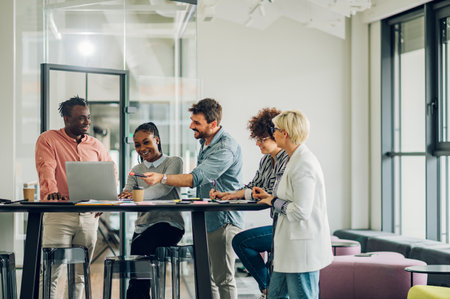 Diverse employees gathered in the office having fun during brainstorming while discussing new ideas for their new project. Multiracial coworkers gather in boardroom discuss ideas in group at briefing.の写真素材