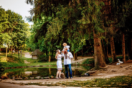 Happy ukrainian family with little son in traditional ukrainian dress in a countryside, parkの写真素材