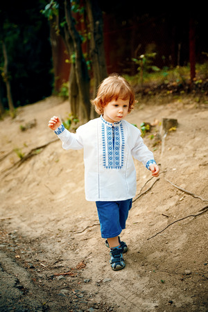 Haired one year old boy plays happily in a parkの写真素材