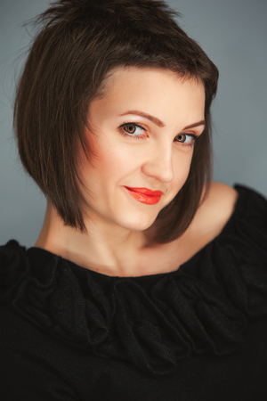 Stylish fashion portrait of a smiling amazing girl with red lips, make up, short  dark hairの写真素材