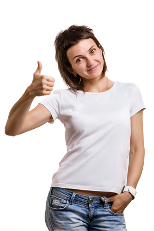 smiling female showing thumbs up. studio shot over white backgroundの写真素材