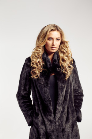Fashion seductive blond hair lady in an elegant fur coat and black underwearの写真素材