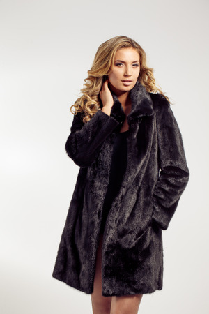 Fashion seductive blond hair lady in an elegant fur coat and black underwearの写真素材
