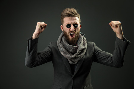Succeded pocker player with raised fists and black chips in eyes.Isolated.