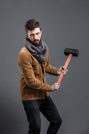 bearded man with hammer on black background