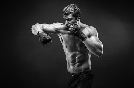 Studio portrait of fighting muscular man in smoke.の写真素材