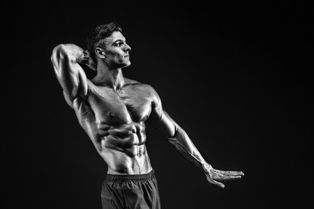 bodybuilder posing. Beautiful sporty guy male power. Fitness muscled manの写真素材