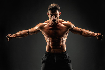 bodybuilder posing. Beautiful sporty guy male power. Fitness muscled man. Roarの写真素材