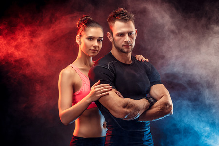 Two fit sportspeople posing together, close to each other. Studio portrait.の写真素材