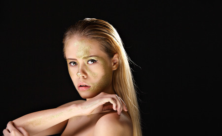 Topless blonde with golden make up . Black background. Isolate.の写真素材