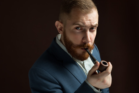 Bearded Lamber like male model in suit with moustache and beard smoking pipeの写真素材