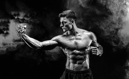 Serious muscular fighter doing the punch with the chains braided over his fist.の写真素材