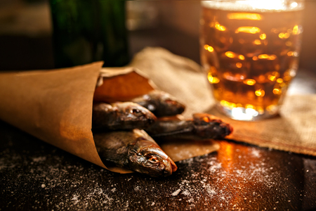 dried fish and vintage glass of beer on a black backgroundの写真素材