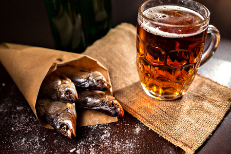 dried fish and vintage glass of beer on a black backgroundの写真素材