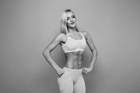 Blonde bodybuilder young adult sexy girl with long hair. Portrait of slim sporty. VERY HOT woman. Copy space. Flat stomach with press.の写真素材