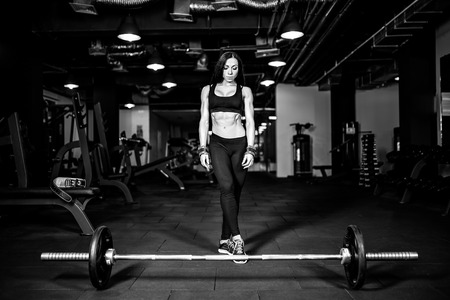 Muscular young fitness woman preparing for heavy deadlift exercise in gymの写真素材