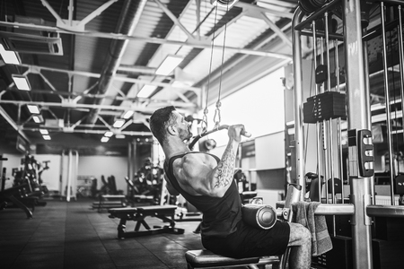 Strong Bearded Bodybuilder Doing Heavy Weight Exercise For Back On Machine.の写真素材