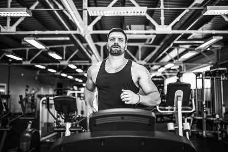 Fit Muscle Man Running on Treadmill in Gym.