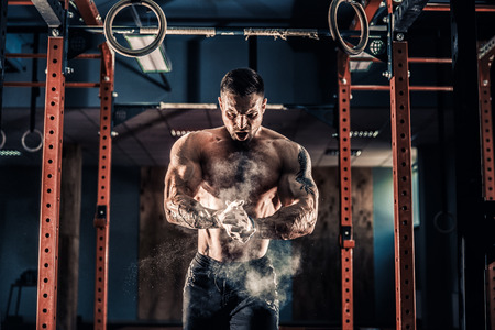 Strong muscular man preparing for workout in crossfit gym. Workout lifestyle concept. Young athlete practicing crossfit trainingの写真素材