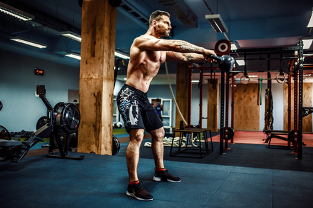 Fitness Kettlebells swing exercise bearded man workout at gymの写真素材