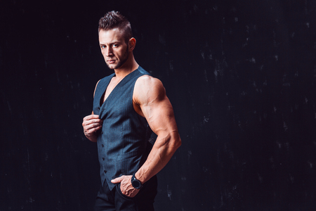 Stylish bodybuilder handsome man looking at camera and posing in waistcoat.の写真素材