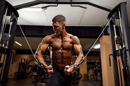 Bodybuilder Is Working On His Chest With Cable Crossover In Gym. Scream for motivation