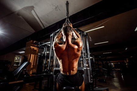 Strong Bodybuilder Doing Heavy Weight Exercise For Back On Machine.