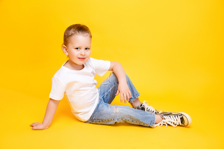 Adorable stylish girl posing on yellow color backgroundの写真素材