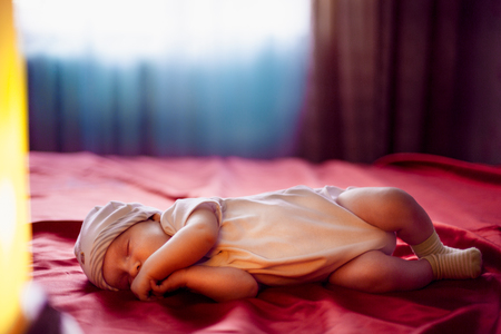 five  months old lovely baby portrait. little boy in blue hat lies on the cover of the bed. sleep.の写真素材