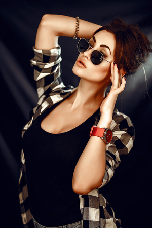 Fashion beauty girl wearing sunglasses, plaid shirt. Image toned.の写真素材