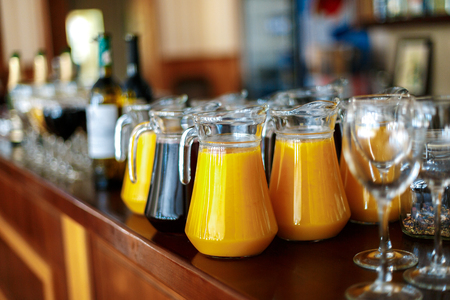 A carafe of fresh juice of orange and grapes on the bar in the restaurant