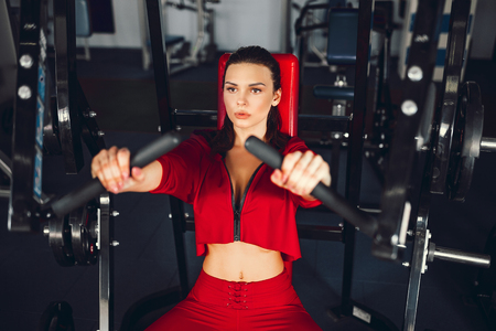 Fit slim young beautiful brunette woman boxing in sportswear. Dark dim light. Toned image