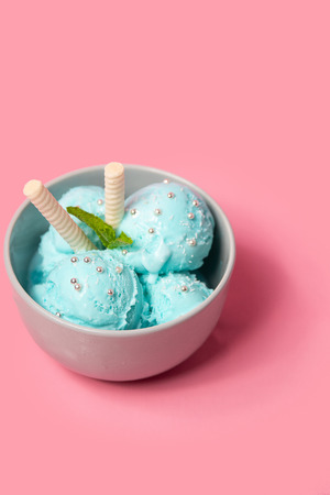 Few scoops Pistachio ice cream with waffle sticks, several leaves of mint in bowl on pink background. copy space. gelatoの写真素材