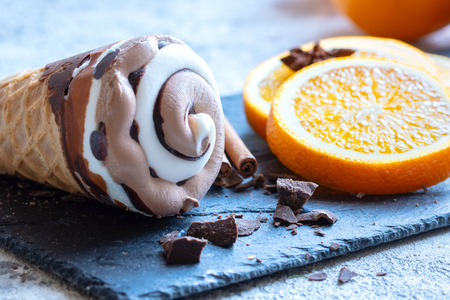 Delicious chocolate and vanilla combo ice cream garnished with fresh orange slices, waffle sticks,...