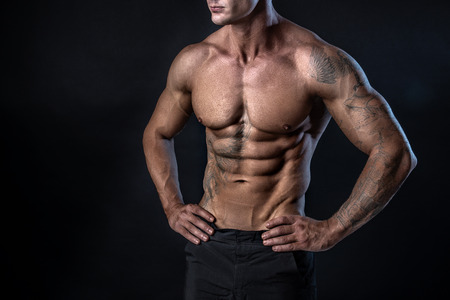 Unrecognizable Strong bodybuilder with six pack. Bodybuilder man with perfect abs, shoulders,biceps,...