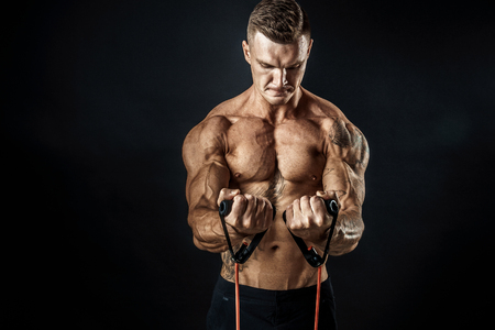 Handsome muscular strong man doing pulling exercise and working hard.の写真素材