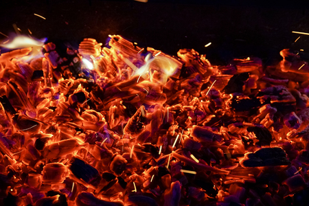 Burning firewood in the fireplace close up, BBQ fire, charcoal background. Charcoal fire with sparksの写真素材