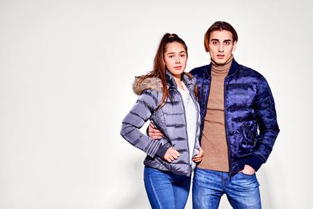 Fashion shot. Couple of young people in winter clothes posing at studio. Autumn and winter clothes.の写真素材
