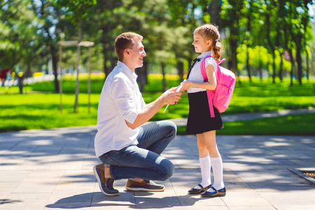 father leads daughter to school in first grade. first day at school. back to school.の写真素材