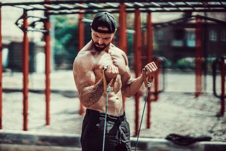 Fitness man exercising with stretching band. Muscular sports man exercising with elastic rubber band. Guy working out with rubber band. Fit, fitness, exercise, workout and healthy lifestyleの写真素材