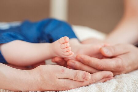 Close up photo of a baby foot in mother hands.の写真素材