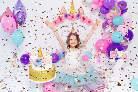 Unicorn Girl throws confetti. Idea for decorating unicorn style birthday party. Unicorn decoration for festival party girl.の写真素材