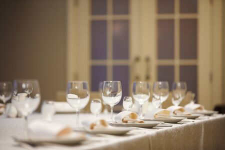 Row of place settings on table for a wedding reception.の写真素材