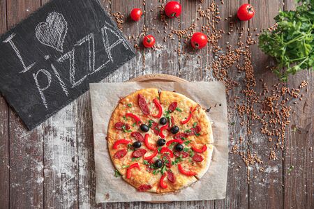 From above piece of pizza on a board with I love pizza on wooden table. I love pizza concept.の写真素材