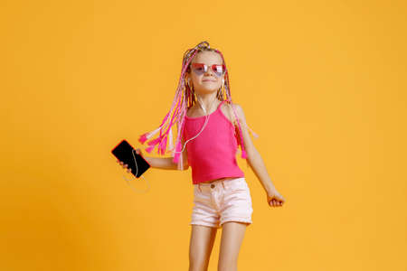 Beautiful European girl with dreadlocks. Mobile phone in the hand.の写真素材