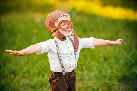 A little boy dreams of becoming a pilot. Vintage aviation hat.の写真素材