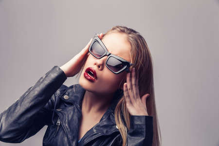 Fashion portrait of young elegant woman in black leather jacket, sunglasses.の写真素材