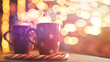 Close-up two glass cups full of hot, red, aromatic drink on table wi blurred christmas background.の写真素材